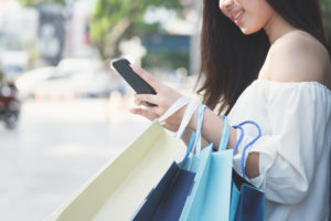 Woman shopping in shopping mall and use mobile phone shopping and find promotion. Business shopping situation idea concept.